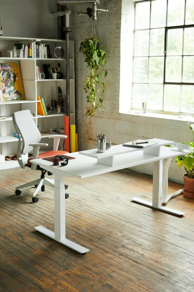 Poste de travail lumineux avec chaise ergonomique blanche et bureau réglable en hauteur, illustration du guide Black Friday