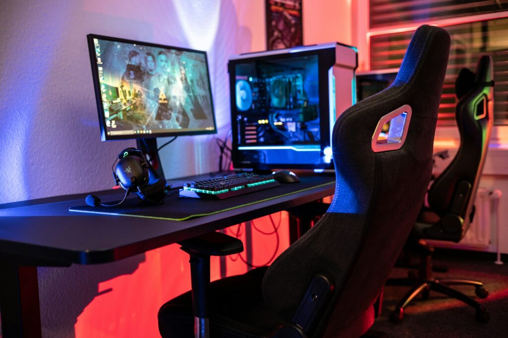Chaise gaming premium noire devant un PC avec éclairage LED rouge et bleu
