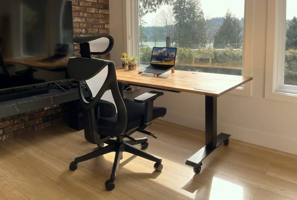Espace de travail avec bureau ergonomique installé près d’une fenêtre