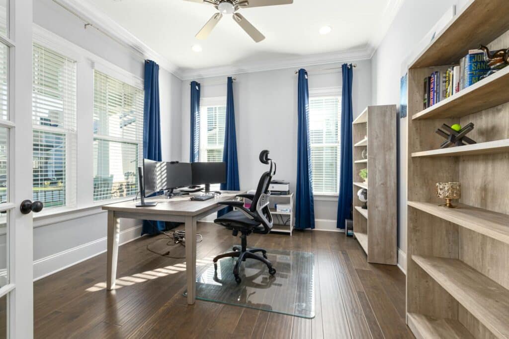Chaise ergonomique devant triple écran dans bureau moderne